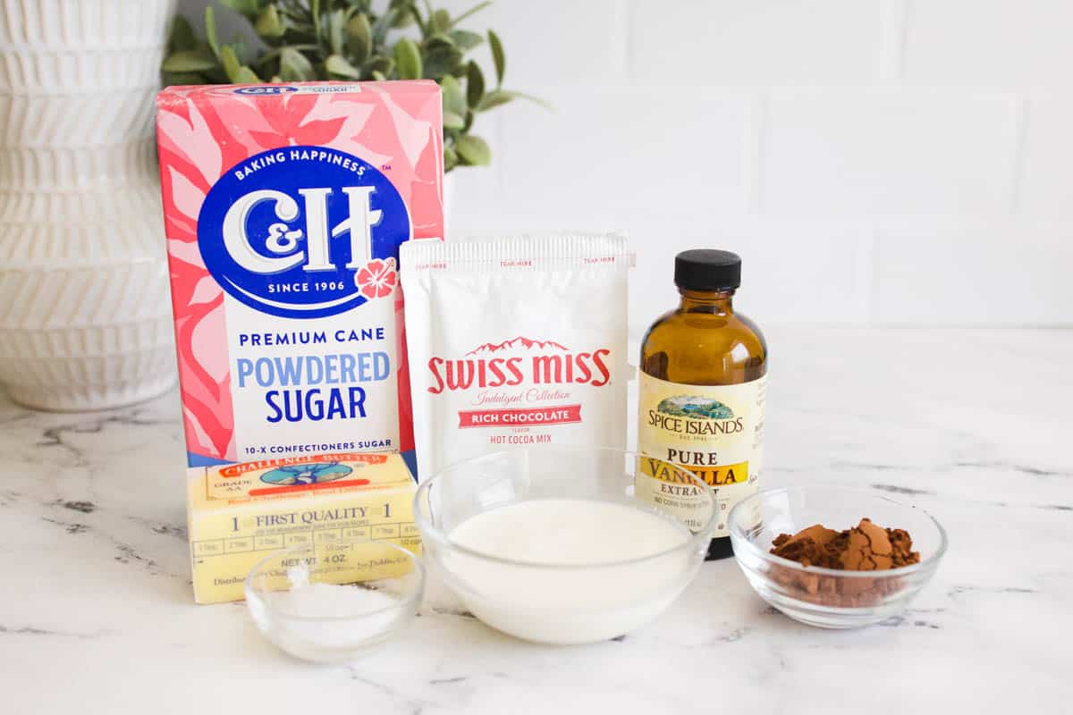 Ingredients to make hot cocoa frosting on a table. 