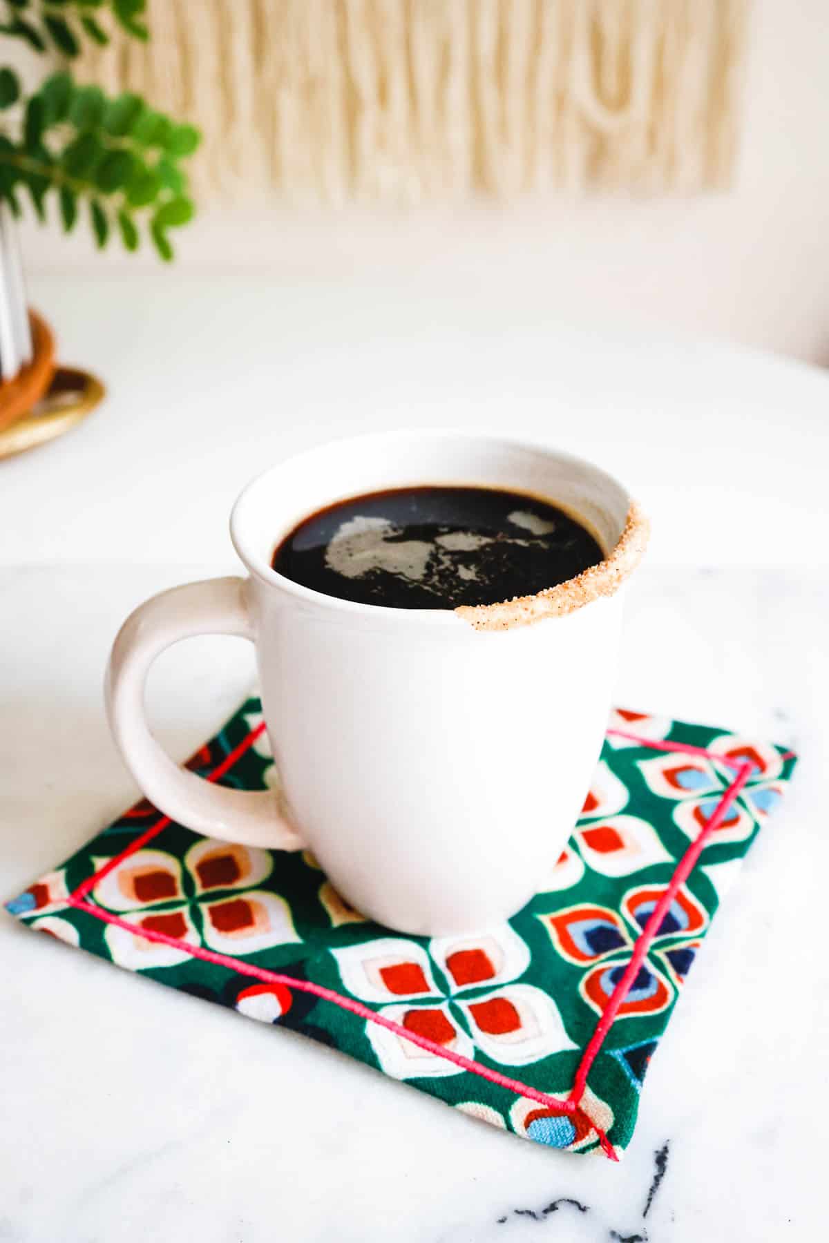 Mug of coffee with a cinnamon sugar rim.