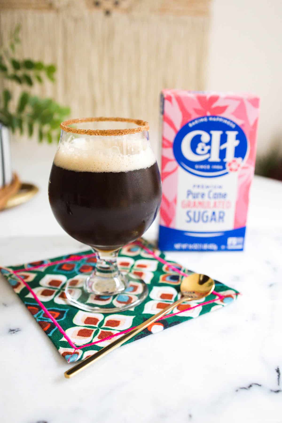 Cinnamon sugar rim on a coffee cocktail with the box of sugar in the background.