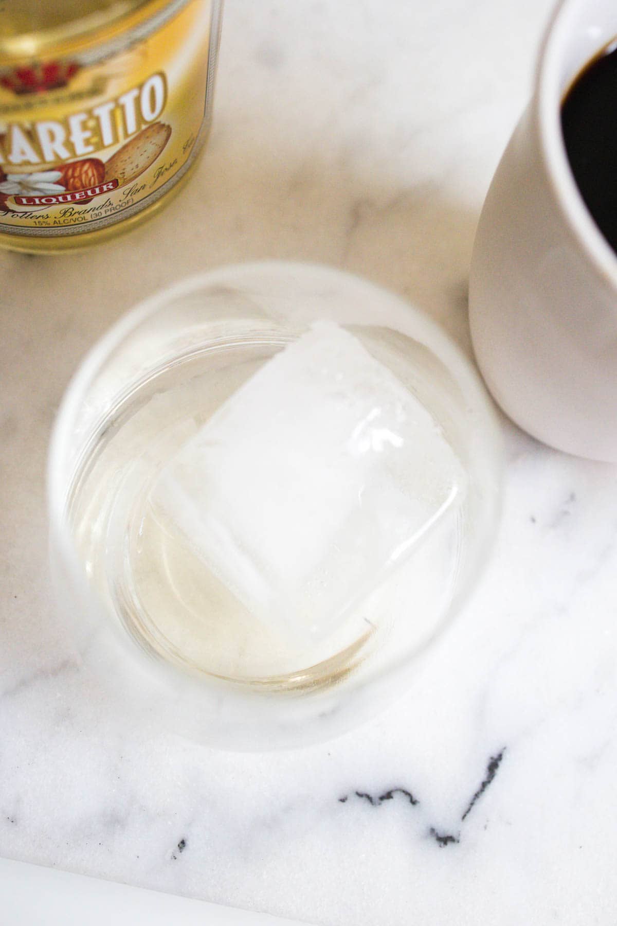 Glass with a giant ice cube and amaretto.