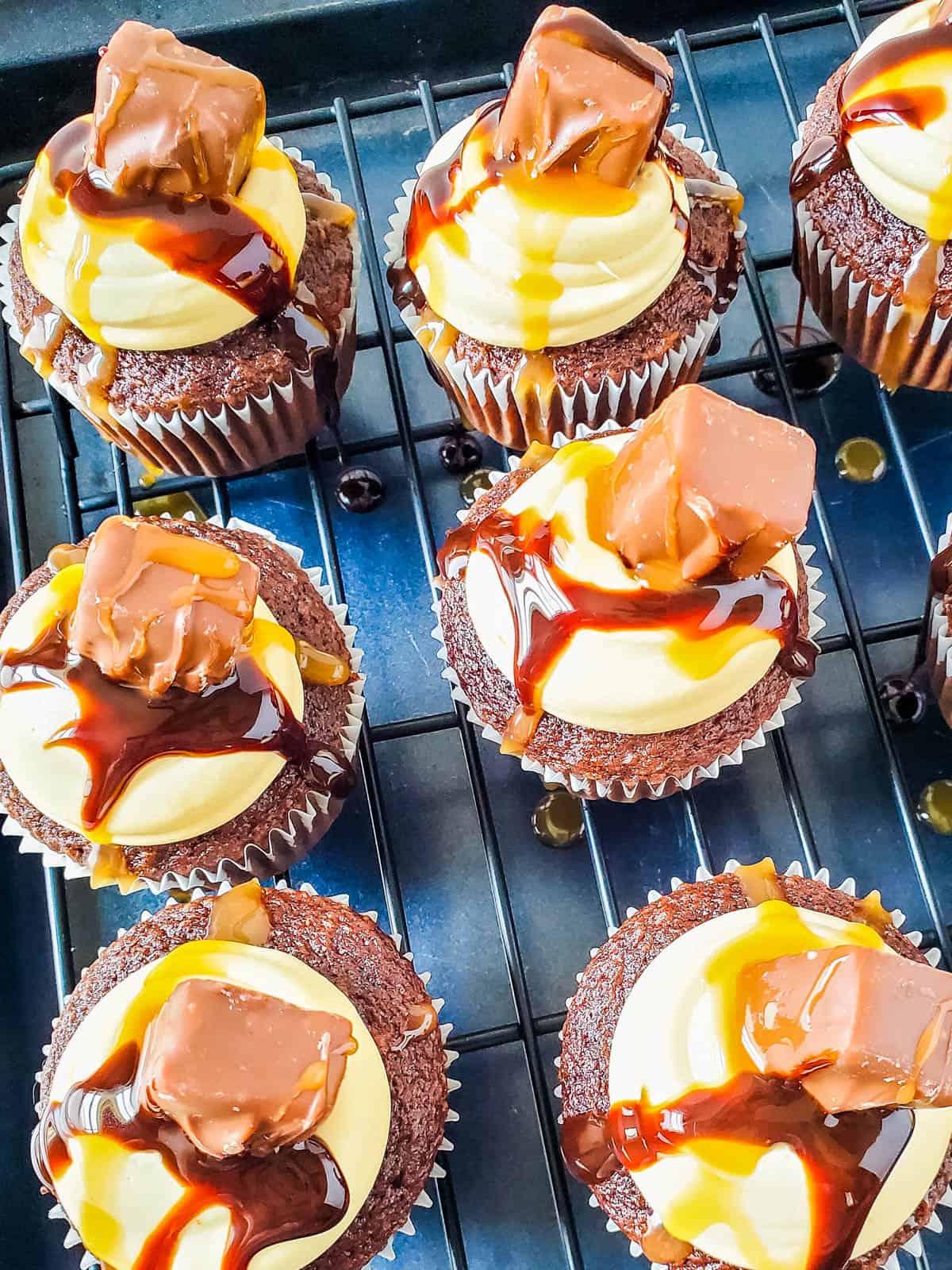 Finished product of snickers cupcakes with cake mix on a wire rack.