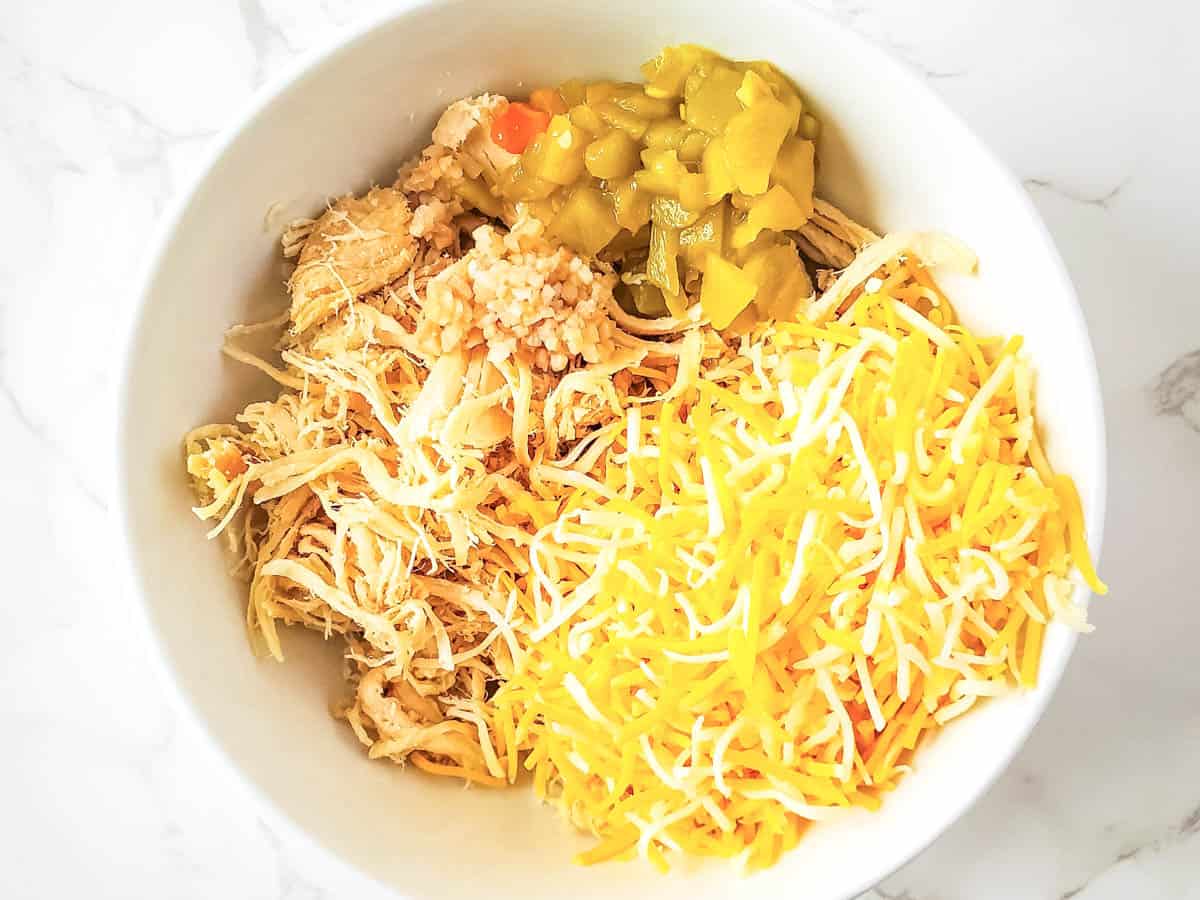 Ingredients for air fryer chicken taquitos filling in a mixing bowl.