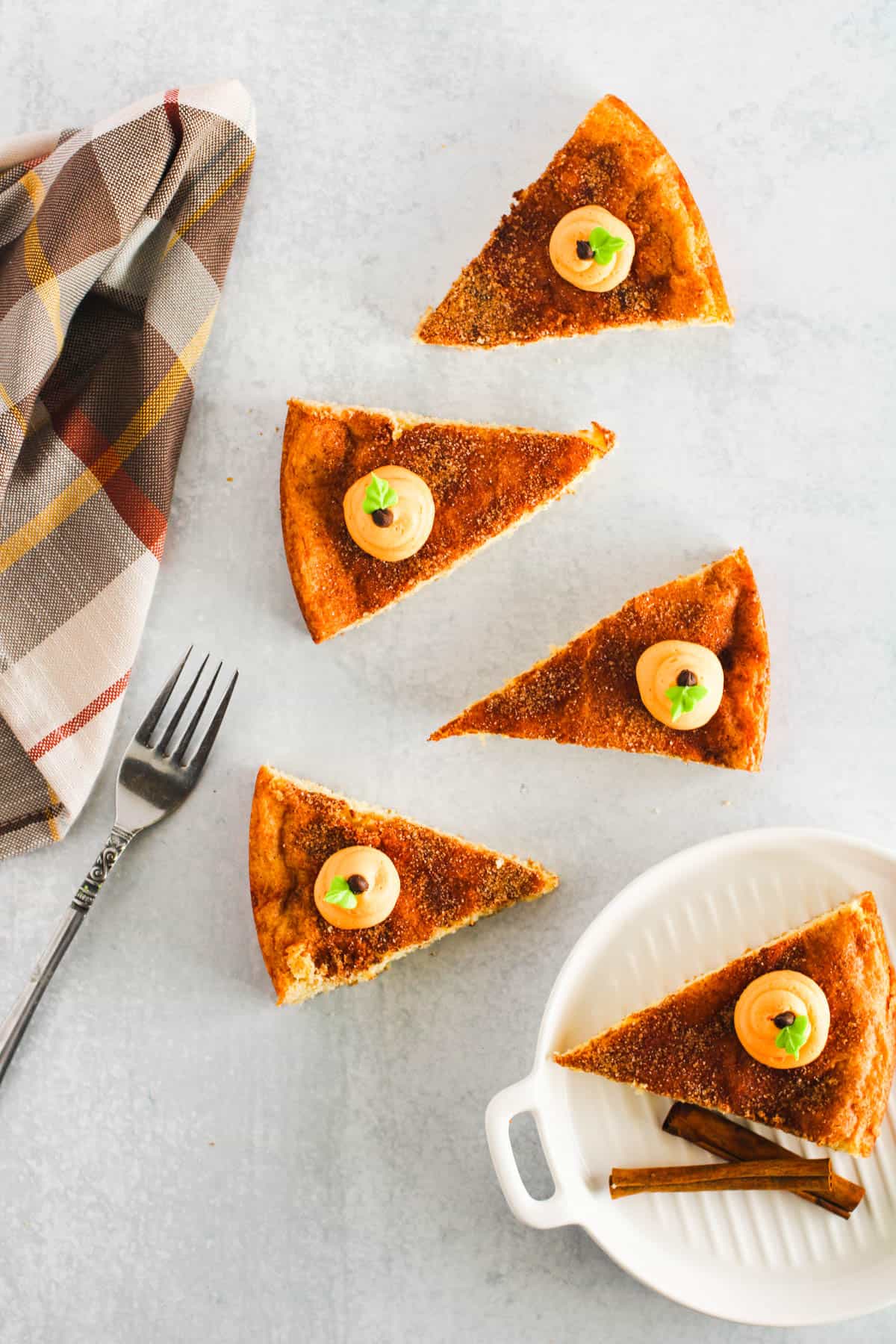 Slices of Snickerdoodle cookie cake on a table next to a napkin and fork.