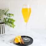 Mimosa with a cinnamon sugar rim on a small black tray.